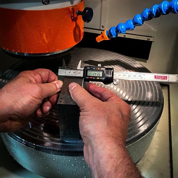 Person Measuring Metal Part
