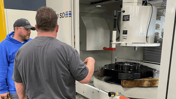 Grinding Machine With Employees Standing Outside Of It